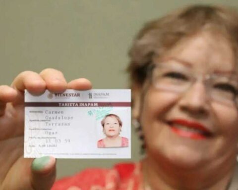 Mujer adulta mayor sosteniendo su credencial del INAPAM.