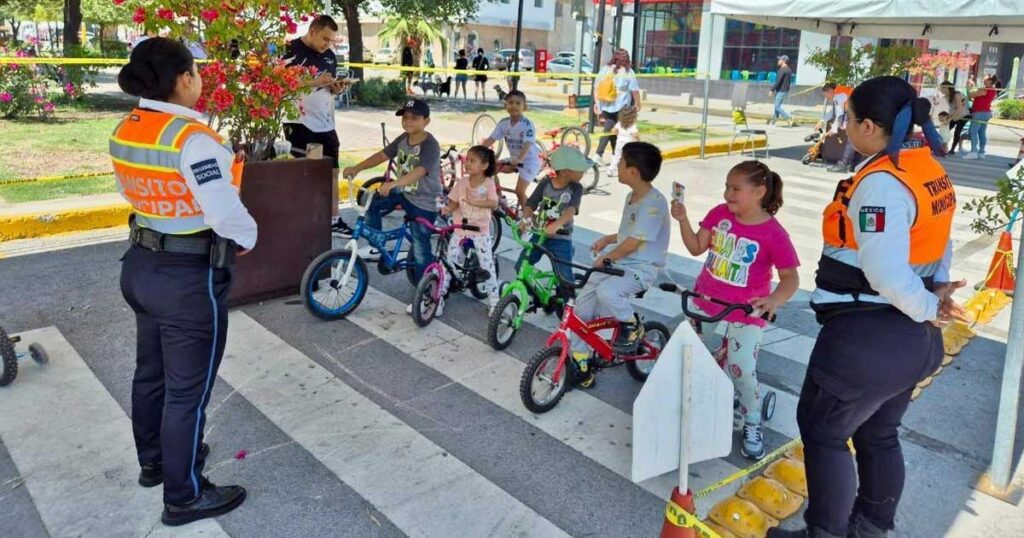 Elementos de vialidad dando instrucciones a niños en bicicletas.