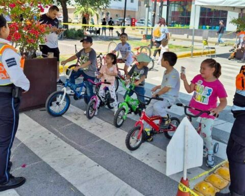 Elementos de vialidad dando instrucciones a niños en bicicletas.