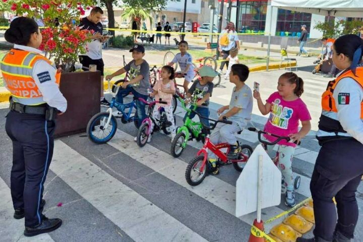Elementos de vialidad dando instrucciones a niños en bicicletas.