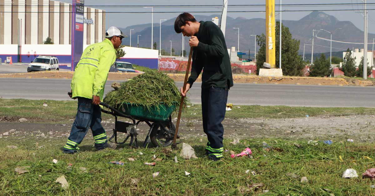 Trabajadores limpiando áreas verdes.