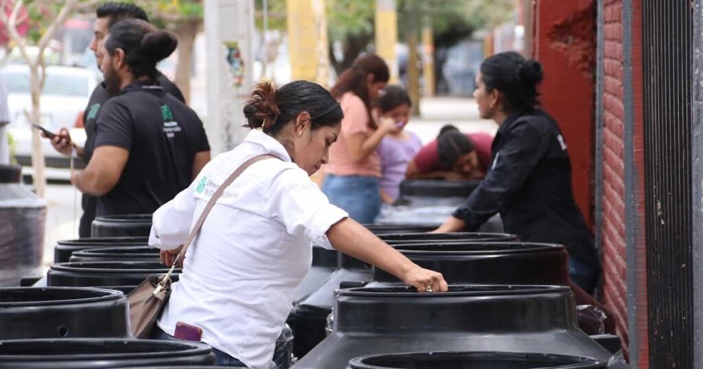 Mujeres revisando los tinacos entregados.