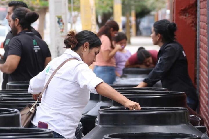 Mujeres revisando los tinacos entregados.