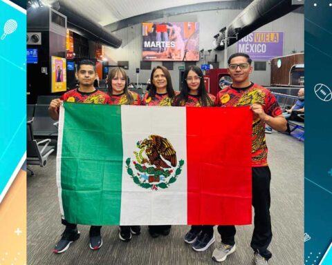 Atletas sosteniendo la bandera de México.