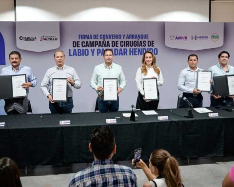 Funcionarios sosteniendo el acuerdo firmado.
